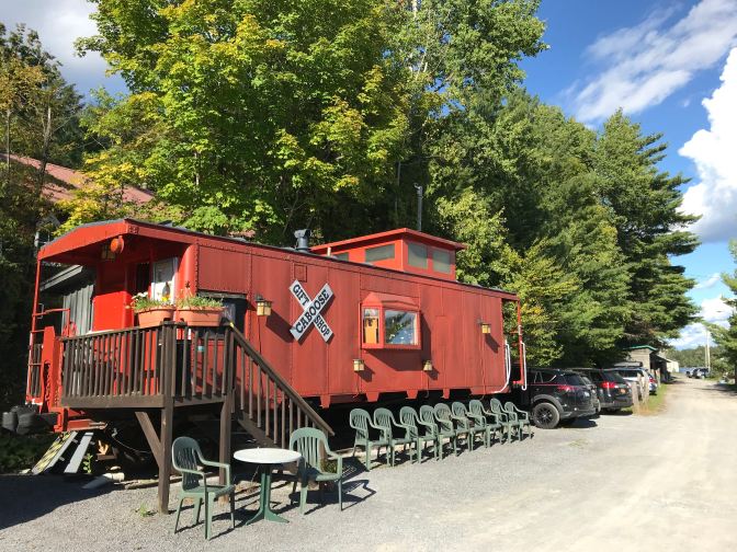 Red Caboose gift shop, with plastic chairs lined up in front of it.