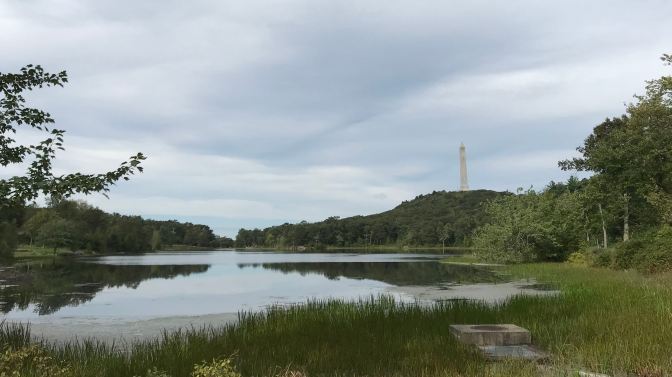 A lake is in the foreground. High Point Monument is in the distance.