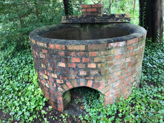 Brick tar pot in backyard of museum.