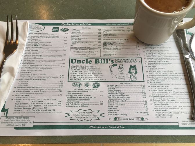 Menu placemat for Uncle Bill's Pancake House, along with a cup of coffee and silverware.
