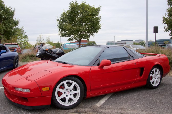 Red Acura NSX with white wheels.