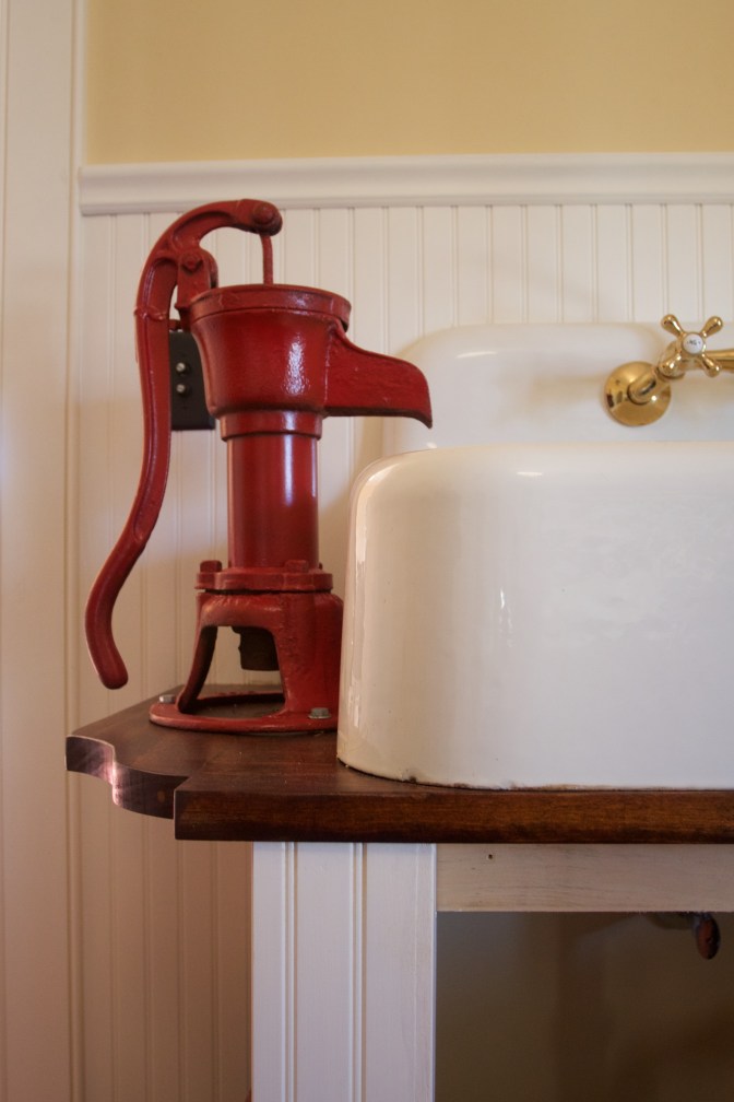Red water pump and sink in kitchen.