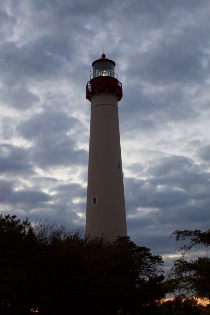 Exterior of Cape May Lighthouse. Trees are in the foreground.
