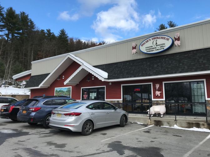 Exterior of Oscar's Smokehouse, with cars parked in the parking lot.
