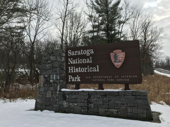 Large roadside sign that says SARATOGA NATIONAL HISTORICAL PARK US DEPARTMENT OF INTERIOR NATIONAL PARK SERVICE.