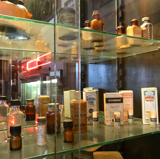 Glass shelves with old medicines and ointments from 100 years ago.