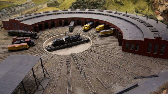 Roundhouse train yard with nine trains in the roundhouse.