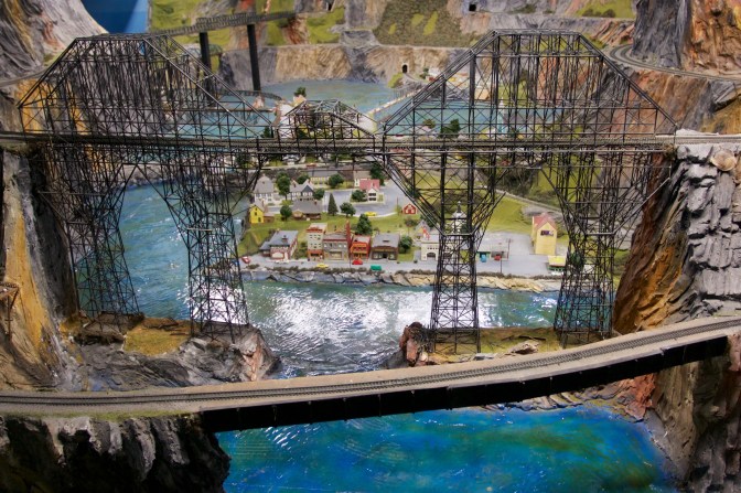 Steel trestle bridge over town and river.