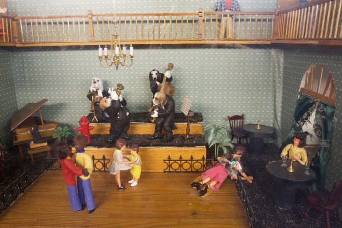 Dolls in a dance hall, dancing to a band composed of dog musicians.