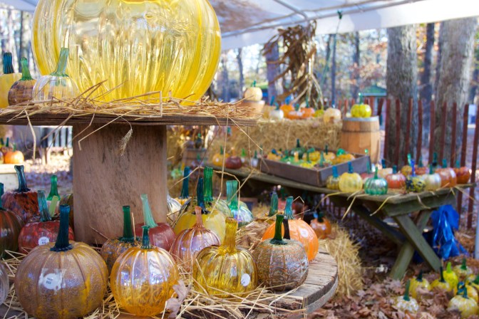Pumpkin patch under large white tent. The pumpkins are all glass.