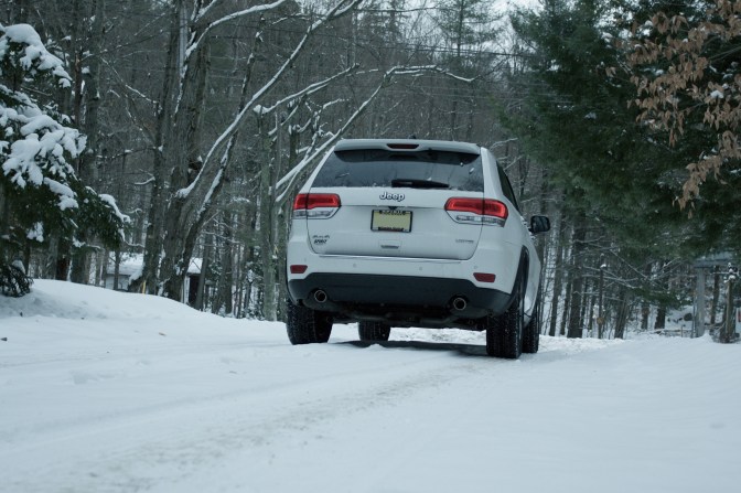 2014 Jeep Grand Cherokee on a snow-covered mountain road.