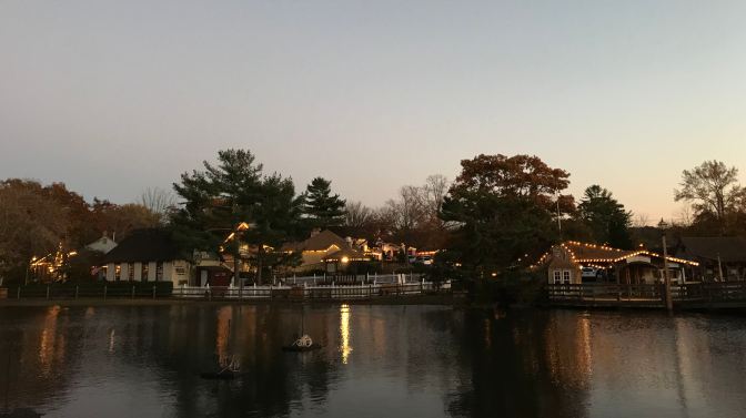 Village buildings on shore by a lake.