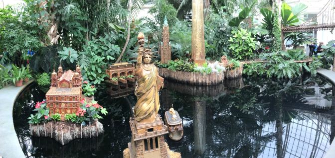Panorama of New York Harbor scene, including Ellis Island and the State of Liberty.