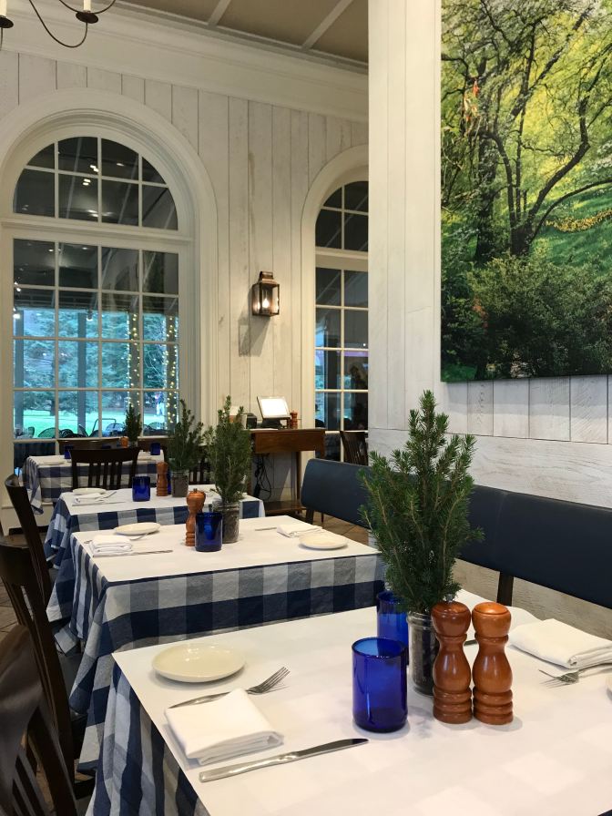 Interior of Hudson Garden Grill. A row of tables is in the foreground.