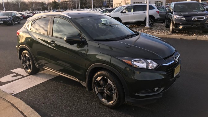 2018 Honda HR-V in green at dealership. Rows of cars and SUVS are in the background.