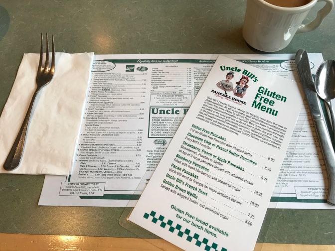 Table with coffee cup, menu placemat, flatware, and gluten free menu at Uncle Bill's.