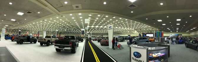 Interior of Baltimore Convention Center, with cars and trucks filling the space.