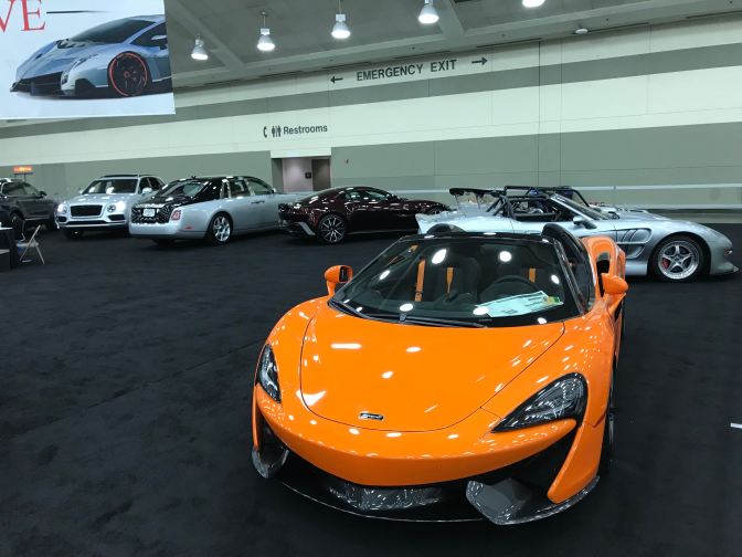 Luxury cars, with an orange McLaren in the foreground.