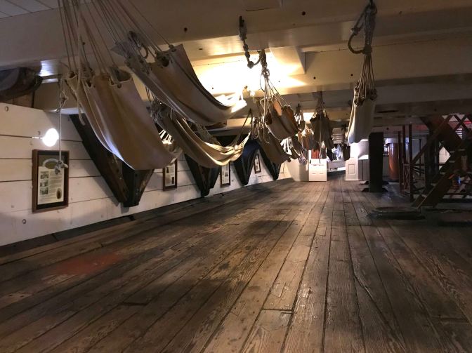 Hammocks suspended from the deck above.