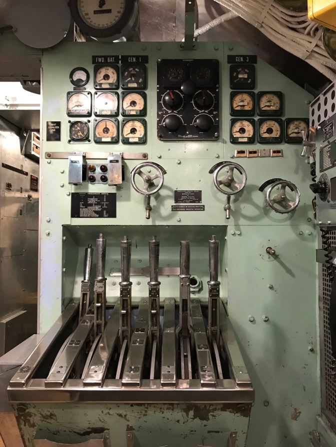 Starboard control station. Gauges are on the wall, along with dials and five levers to control speed.