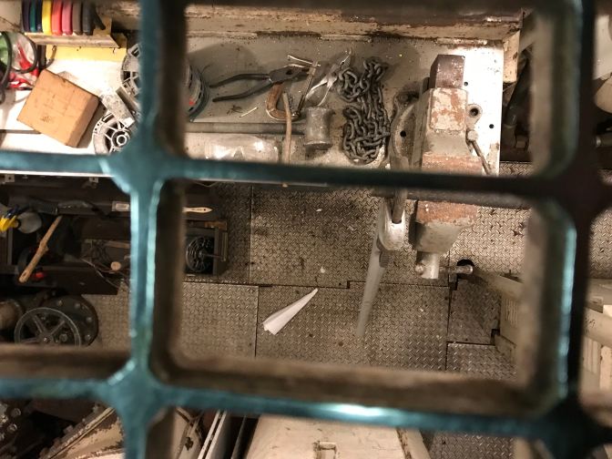 View down into machinist shop through a grating.