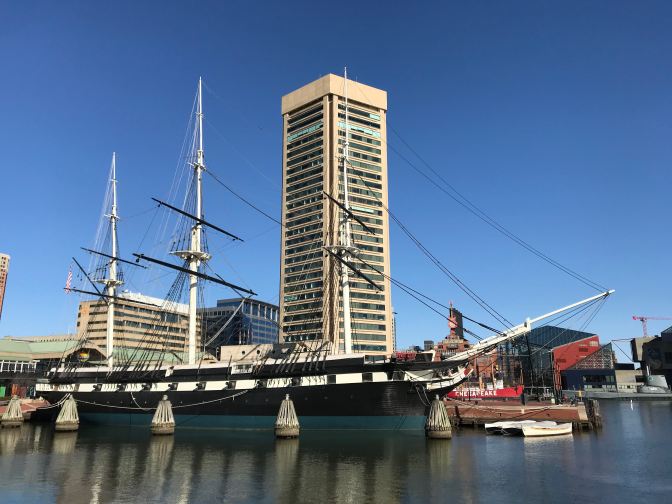 USS Constellation, at anchor, with the Baltimore World Trade Center in the background.