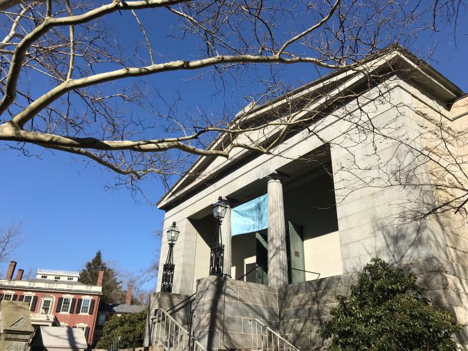 Exterior of the Providence Athenaeum, with a tree branch in the foreground.