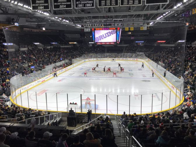 View of hockey game from behind the goaltender.