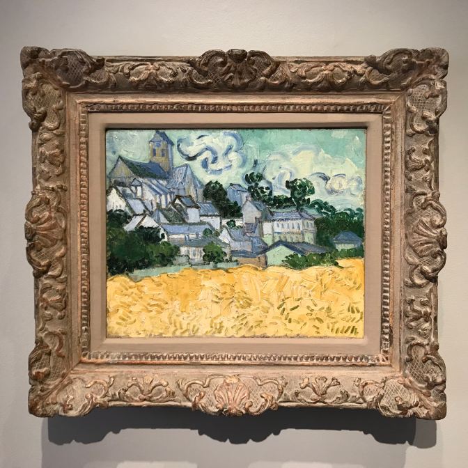 Painting by Vincent Van Gogh, View of Auvers-sur-Oise, which has a small town above a field of grain.