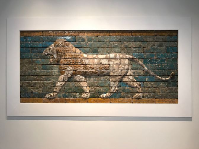 Brick mosaic of a lion on a wall.