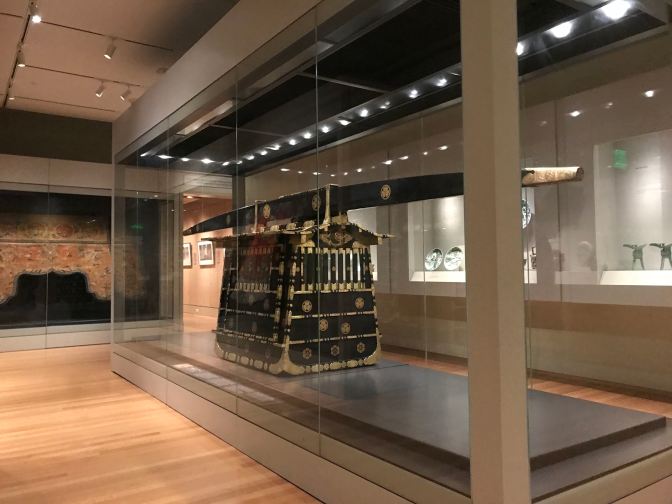 Black wood palanquin with gold painting. A large rail above the litter is used for attendants to carry the litter.