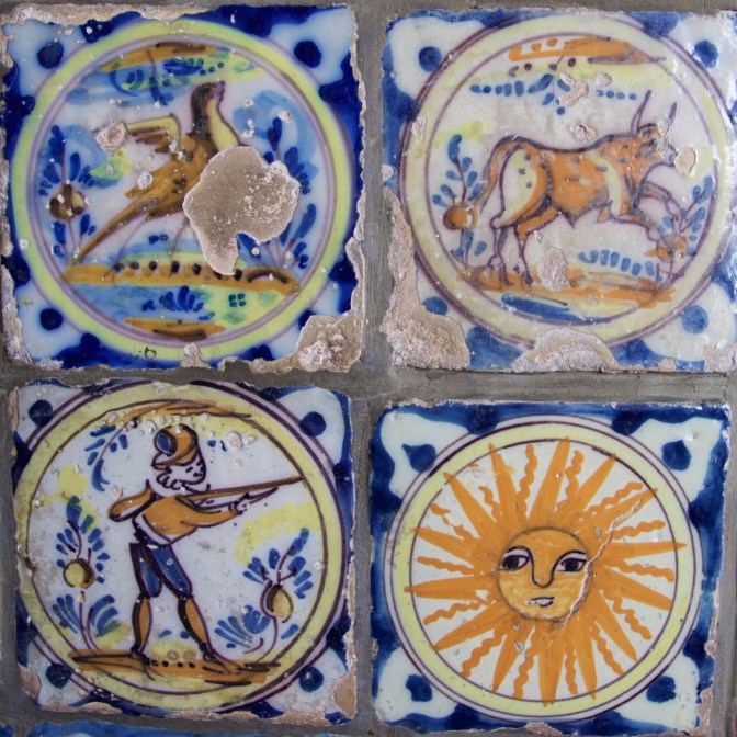 Four tiles - one of a bird, one of a cow, one of a soldiers, and one of the sun, all on a blue and white patterned background.