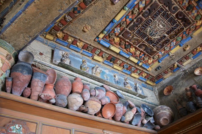 Ancient pottery, held up by netting.