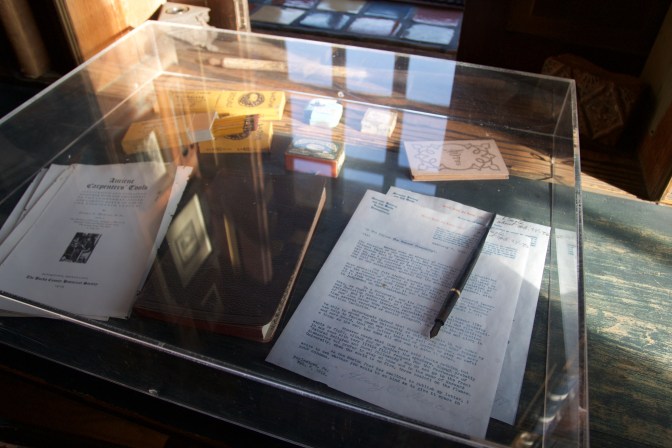 Items on Henry's desk in his study, including a letter, matches, books, pencils, journals, and a pen.