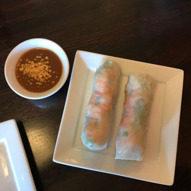 Platter with summer rolls and a small bowl with peanut sauce.