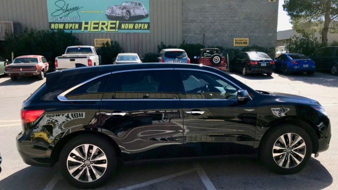 2016 Acura MDX in black in front of warehouse.