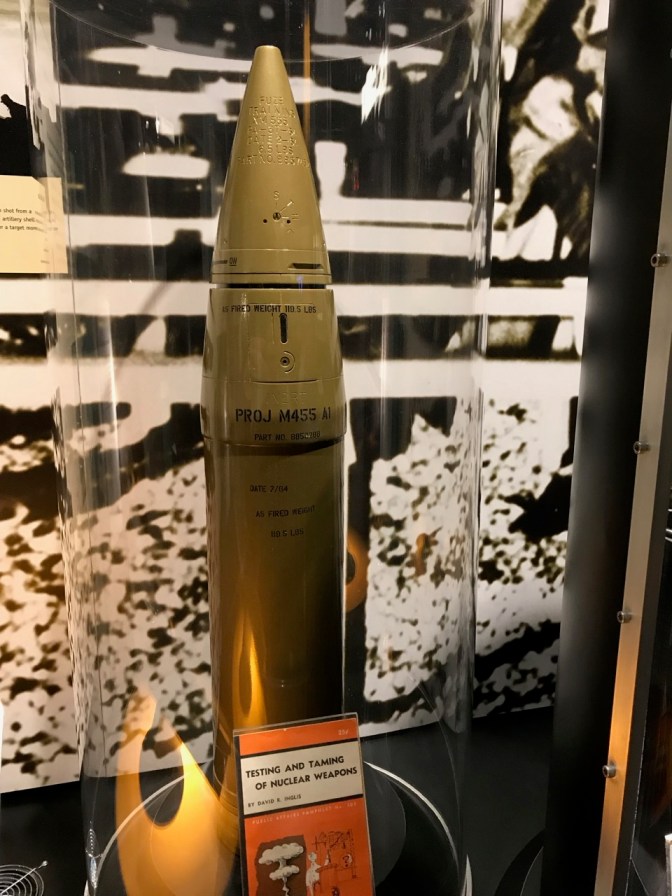 Brass-colored W33 nuclear artillery shell, in a glass case.