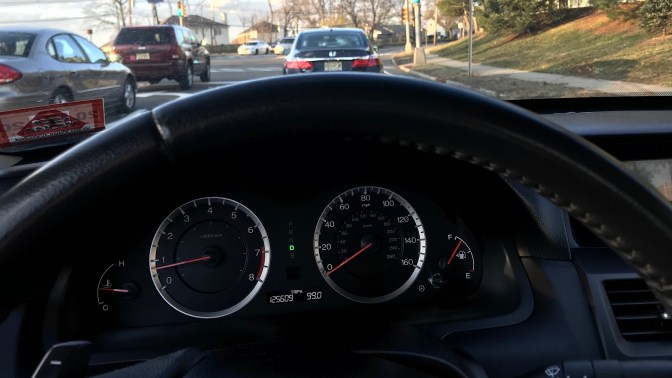 Dashboard of 2012 Honda Accord coupe. Looking through window shows traffic at stoplight.