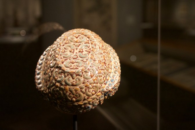 Warring State earthenware cup, covered in elaborate glass decorations.