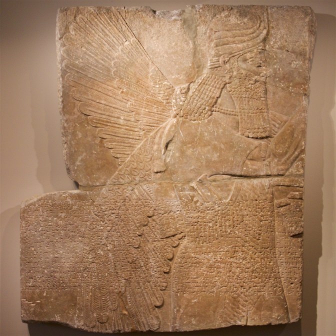 Engraving of a winged deity on a stone tablet.