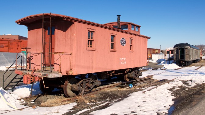 Red wooden caboose with NYC 19322 on the side.