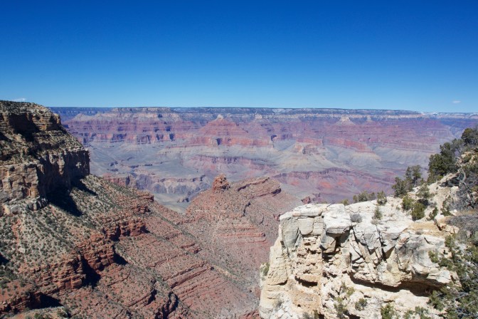 View of the Grand Canyon. Cliffs are in the foreground.