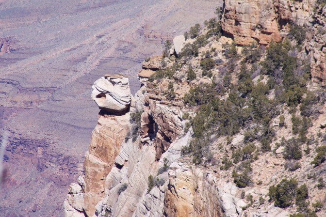 Boulder perched on side of cliff.