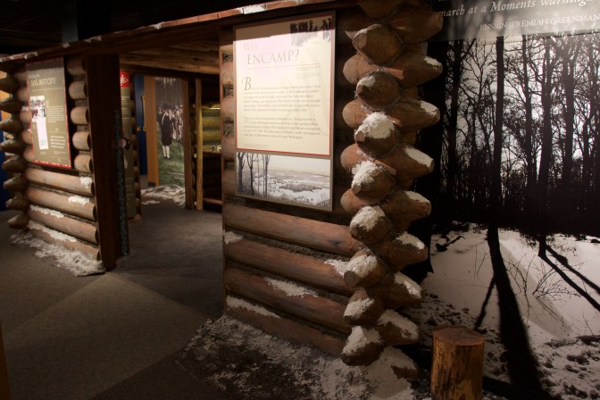 Recreation of 18th century barracks with information placards on walls.