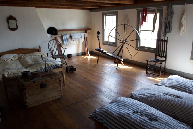 Servants quarters, with a bed, several bunks and a spinning wheel.