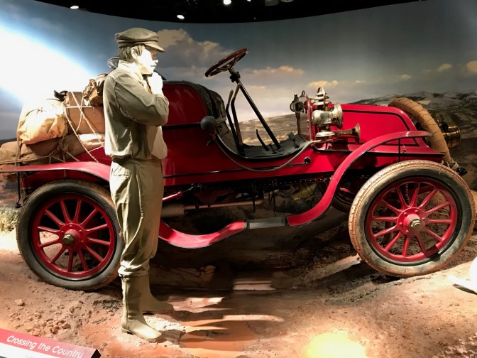 1903 Winton automobile, with a mannequin of a man representing an early auto pioneer in the foreground.