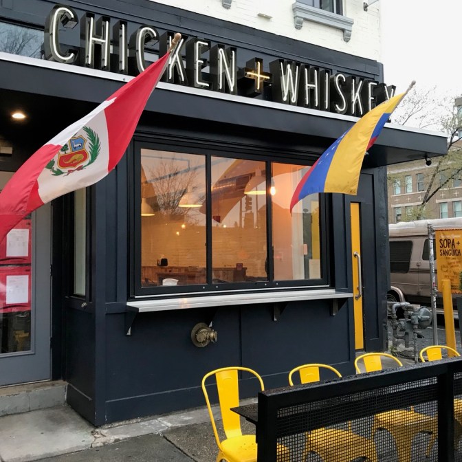 Exterior of Chicken + Whiskey, with Peruvian flags flying in the foreground.