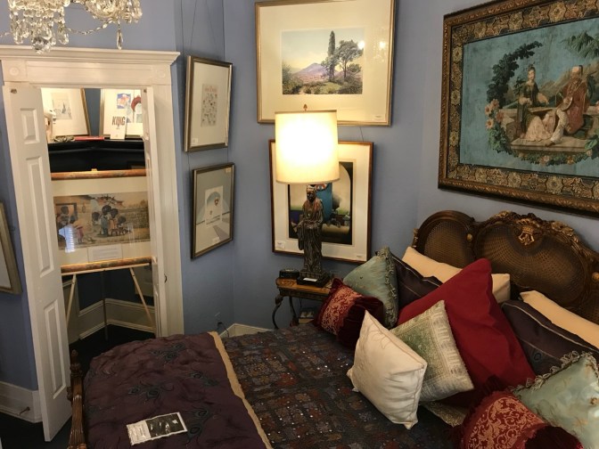 Rosa Parks room, with paintings on the wall, a bed in the foreground, and another painting in the closet.