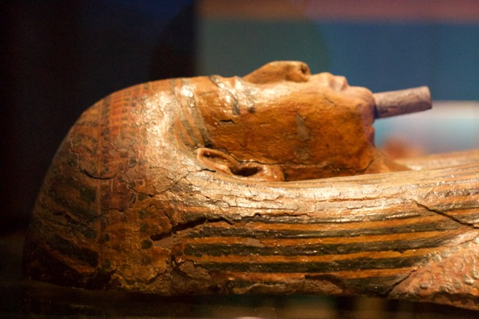 Wooden mummy case, painted in gold.