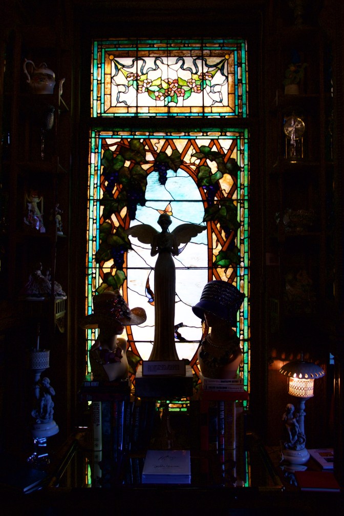 Stained glass windows, with statues in the foreground.
